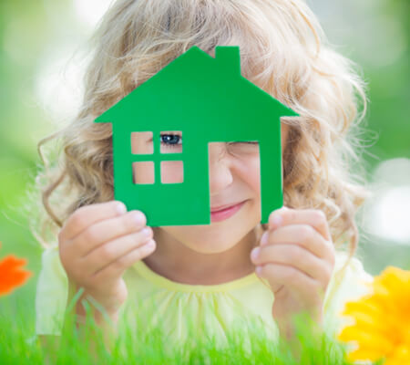 Child playing with a wooden toy house